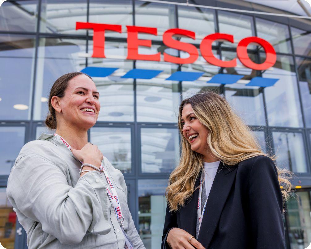 Two female colleagues outside Tesco Heart building laughing
